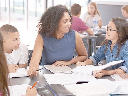 Students learning different languages in a classroom with their teacher
