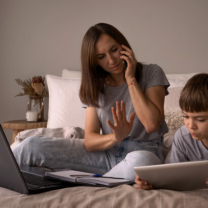 Mulher trabalhando no celular e criança usando tablet. Defina limites claros
