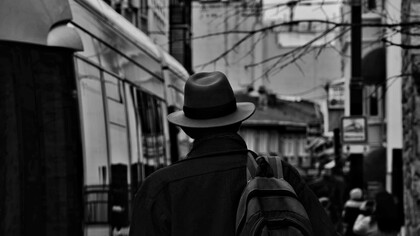 A man wearing a hat and carrying a backpack