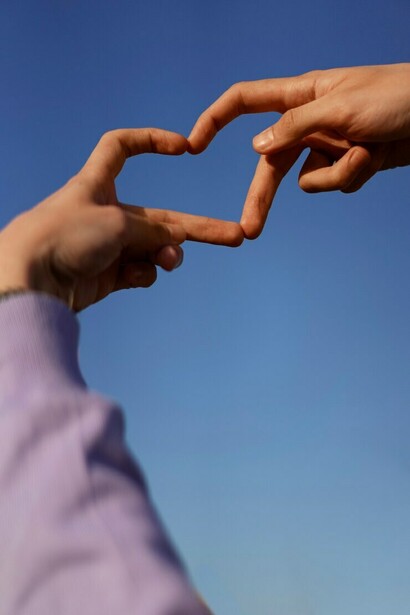 Low-angle shot of hands forming a heart gesture