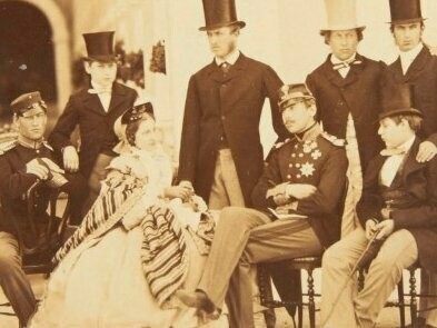 Membros da família real portuguesa em 1861. A invasão napoleônica a Portugal, em 1807, forçou a “fuga” da família real para o Brasil, um evento épico que transplantou o centro de um império para uma colônia. Foi nesta terra, longe da etiqueta rígida da corte de Lisboa, que o jovem príncipe cresceu. Ele desenvolveu uma personalidade livre, quase selvagem, preferindo cavalgar pelos campos do que estudar nos livros, e demonstrando desde cedo um talento notável para a música, compondo modinhas e peças que revelavam um temperamento sensível e apaixonado. Essa formação "brasileira" foi crucial; foi no Rio de Janeiro que Pedro aprendeu a amar a terra e o povo que um dia lideraria