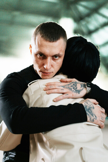 Hombre abrazando a una mujer con mirada violenta