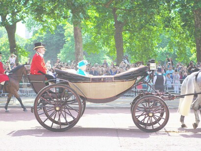 Queen Elizabeth traveling by horse carriage near Buckingham Palace, England