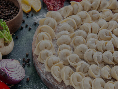 Beautifully arranged and expertly stuffed manti lie on the tray