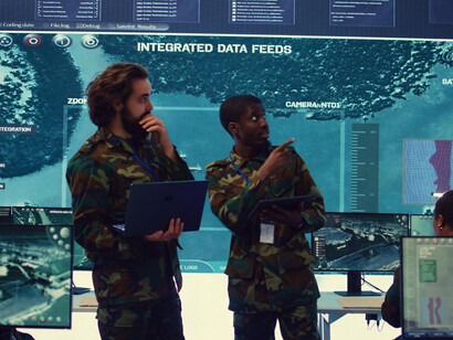 Commanders consult on strategic updates, showcasing the integration of military intelligence and civilian cybersecurity 