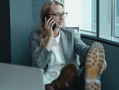 A woman smiling as she's on the phone trying to preserve her purpose