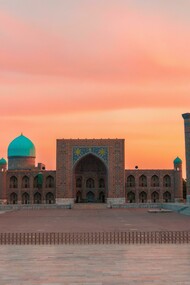 Registan Square in Samarkand, Uzbekistan, glowing at sunset as its blue-tiled madrasas shimmer like a doorway into another age