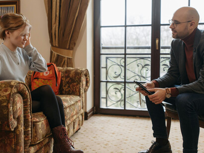 A man working as a life coach is speaking thoughtfully to a woman, offering guidance and support as she shares her personal challenges