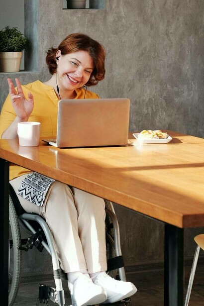 Woman on a wheelchair waives while at work