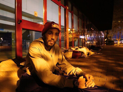 Farid, de origen marroquí, se dispone a dormir sobre un cartón en la cubierta del Polideportivo Municipal José Antonio Gasca, en el barrio donostiarra de Amara. Foto: Iker Azurmendi