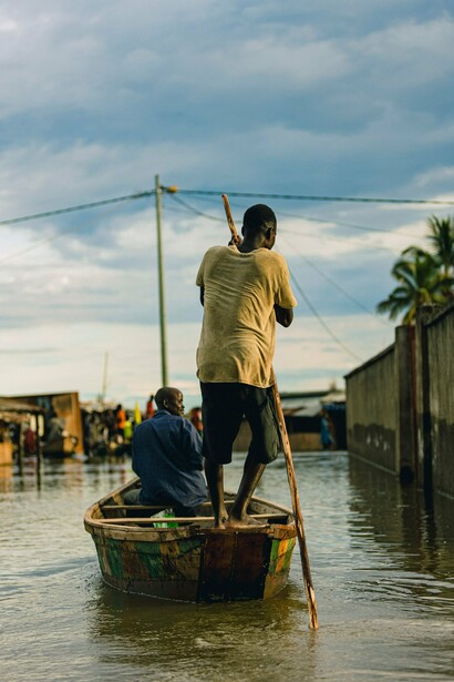 A resident transporting people through flood-affected streets, symbolising the need for stronger climate adaptation and disaster preparedness