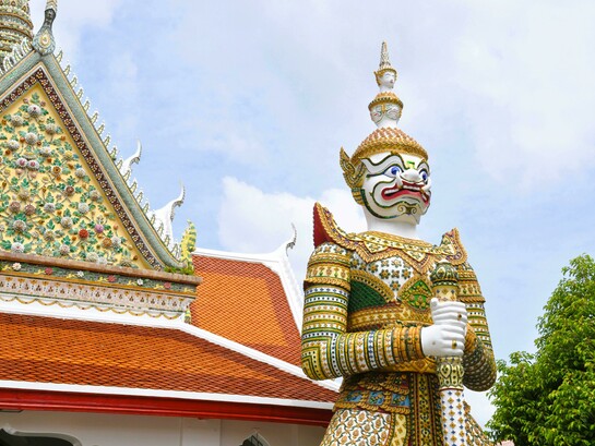 Yaksha and Yakshini sculptures at an Indian temple; giant guardian statue at a Thai Buddhist temple