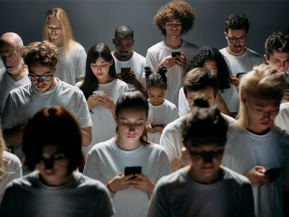 Uma multidão de pessoas utiliza smartphones, cada uma concentrada em seu dispositivo. Nas redes sociais, a circulação massiva de conteúdos pode ampliar a influência de determinados discursos e favorecer a repetição de ideias, reduzindo o espaço para o confronto crítico e a diversidade de perspectivas