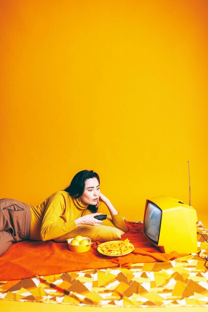 Woman munching on snacks and watching tv