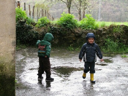 Dos niños saltando en los charcos