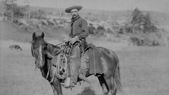 Vista lateral de un vaquero a caballo, mirando hacia la cámara, c. 1888