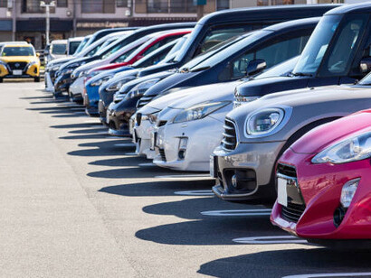 Newly built cars are lined up in a lot, prepared for international export