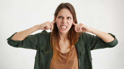 Mulher tapando os ouvidos. A  Maria não gosta de ouvir música