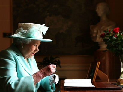 La reina Isabel II firma un documento