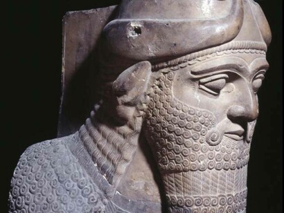 A sculpture discovered by Austen Henry Layard of a bust from a male bearded head from a human-headed, winged bull figure with the horns and ears of a bull