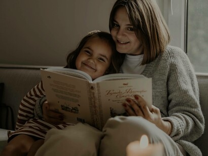 A mother and daughter reading a novel together in the modern age