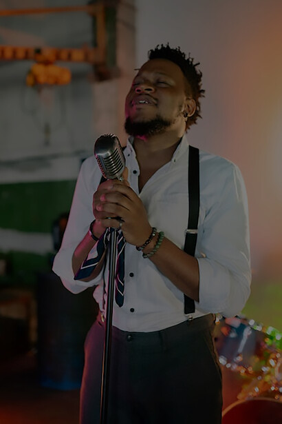 On the stage, a charismatic figure holds a microphone, delivering an electrifying concert that resonates with the eager audience