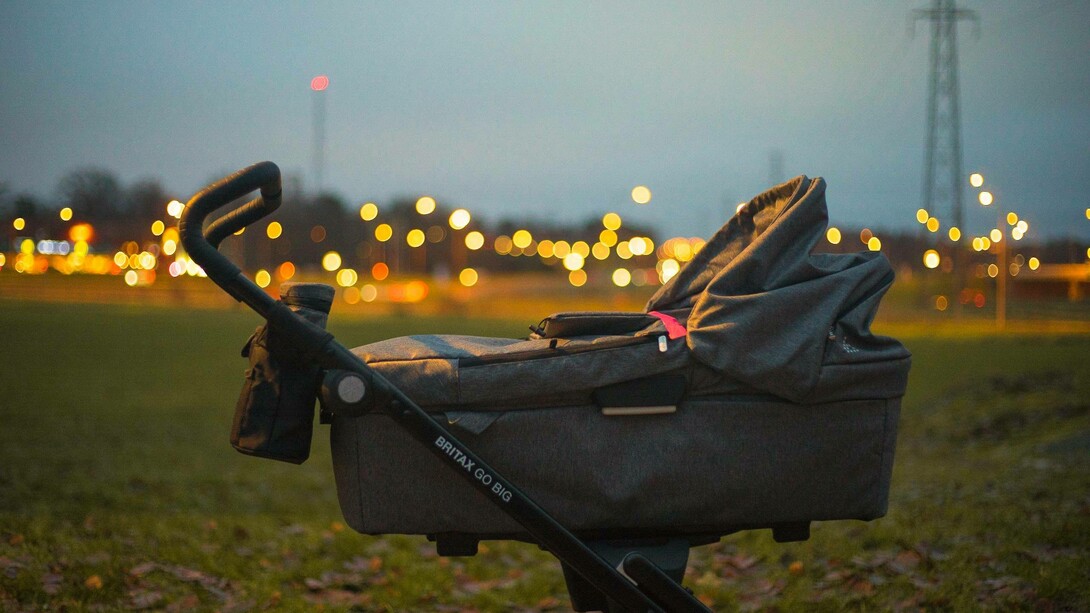 A stroller left alone in the park as it's getting dark
