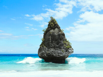 Several rocks rise from turquoise waters, representing the coastal identity and ecological beauty