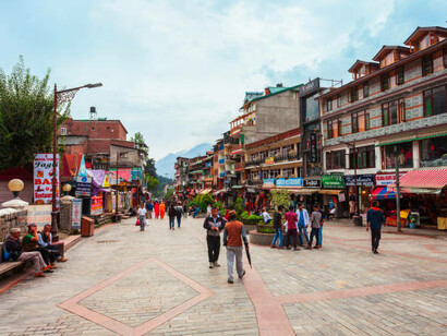 The bustling Mall Road in Manali, Himachal Pradesh, India, filled with people exploring vibrant shops, cozy cafes, and lively street vendors against the backdrop of scenic mountain views