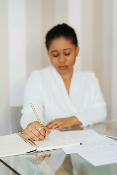 Mujer escribiendo en un cuaderno sus planes. El ser humano tiene muchos planes que se pueden clasificar según los objetivos