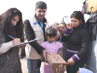 Syrian refugees gather to receive humanitarian assistance at a municipal-run camp in Suruç, southeastern Turkey