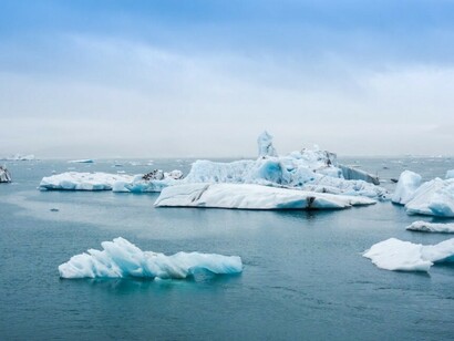 A daytime photo showing icebergs and melting glaciers, highlighting the impact of global warming