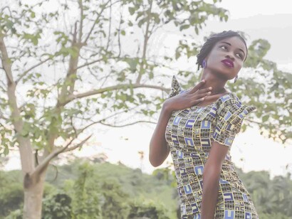 A beautiful black woman posing in a park expressing her freedom of movement and choice to be whoever she chooses to be and acts how she chooses to act
