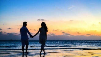 Couple holding hands on the beach