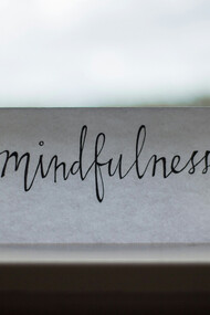 Papel com escrita "mindfulness". O "Mindfulness" é a consciência plena que envolve observarmos os nossos pensamentos sem julgamento