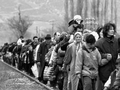 Refugiados caminando por las vías del tren