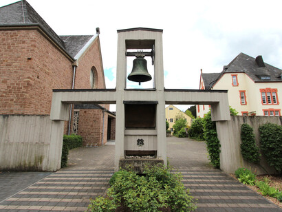 El monumento a Maximilian Kolbe con fuente y reloj de sol en la explanada de la iglesia de Mettendorf, Alemania