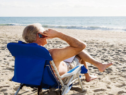 Hombre hablando por el móvil en la playa
