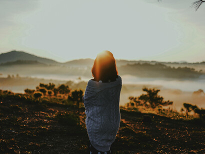 Dalat, Lâm Đồng, Vietnam woman standing on a mountain overlooking a scenic landscape