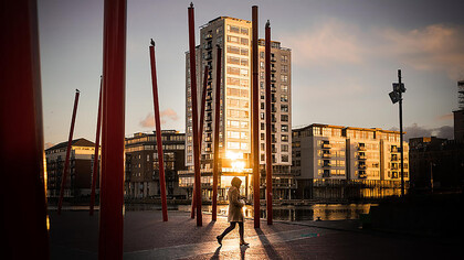 A woman walking through the streets of Dublin, Ireland, at sunset