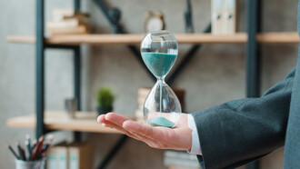 A businessman holding an hourglass in his office