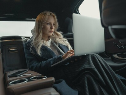 A woman using travel time to stay productive, reflecting society’s growing discomfort with idle moments