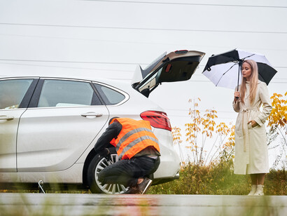 Donna che assiste al cambio della gomma: "Lavorare sull’acquisizione di capacità pratiche non significa né fare tutto da sole, né allontanarsi dalla femminilità"
