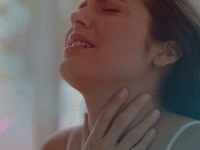 A woman with throat soreness is looking up in pain