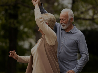 Joyful elderly couple enjoying an active lifestyle in the park, promoting healthy brain aging and longevity, dancing together