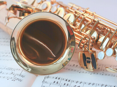 Un saxofón encima en un cuaderno de partituras