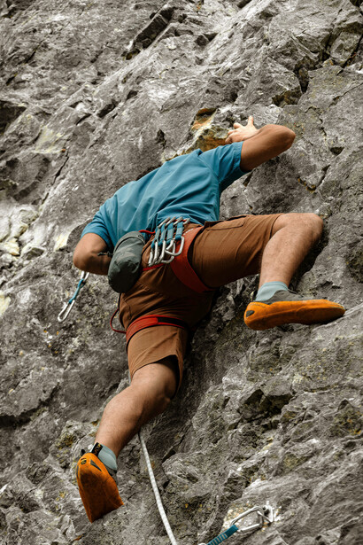 A focused rock climber ascends a steep cliff in Yalova, Türkiye, demonstrating strength, precision, and determination
