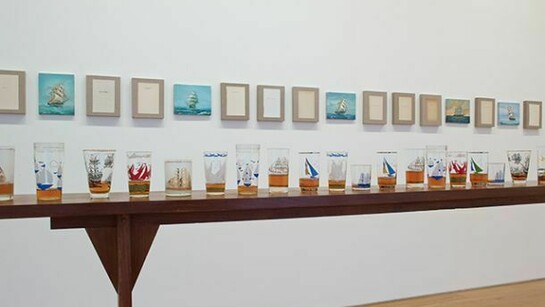 Valeska Soares, Not All Who Wander Are Aimless, 2014, Canvas, book pages, rum, nautical glasses, nautical paintings, reclaimed wood table, 11 canvas and book pages, 20.32 x 25.4 cm, 5 nautical paintings, 20.95 x 25.4 cm, 1 table, 415.5 x 110.5 x 30 cm, 34 nautical glasses, courtesy of Max Wigram Gallery and the artist
