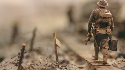 Soldier walking on wooden pathway surrounded with barbwire 