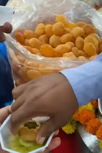 A street vendor in Mumbai, India, preparing fresh gol gappas for customers